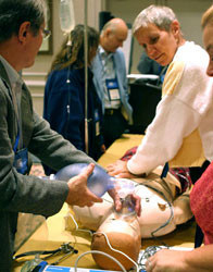 Participants get hands-on with a high-fidelity mannequin in a critical emergency room simulation run through.